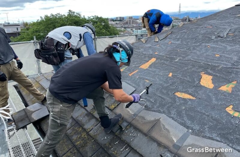 屋根葺き替え作業で古い屋根材を撤去している作業員画像