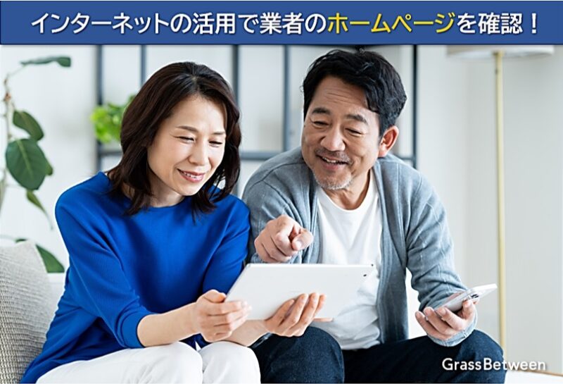 タブレットで業者ホームページを見る夫婦画像